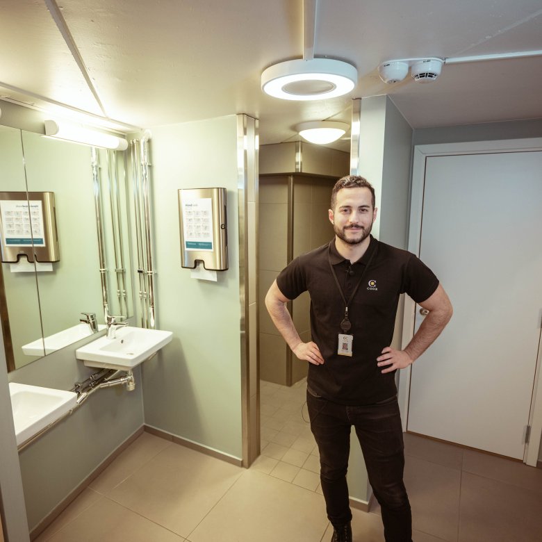 Mannlig driftstekniker i jobbsituasjon på et toalett