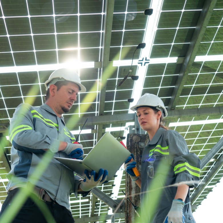 En mann og en kvinne arbeider under solcellepanel 