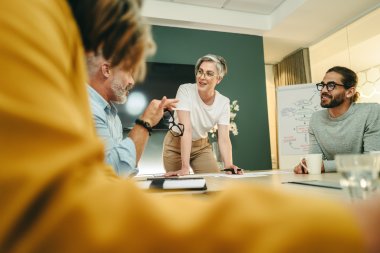 Personer diskuterer strategisk ledelse og innovasjon i et møterom.