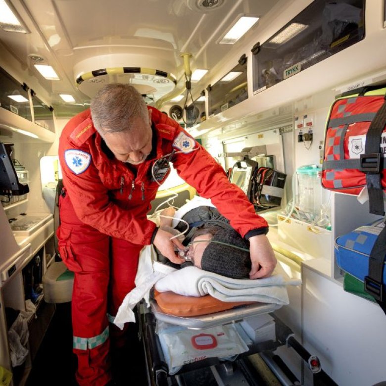 Pasient og ambulansearbeider inne i ambulanse